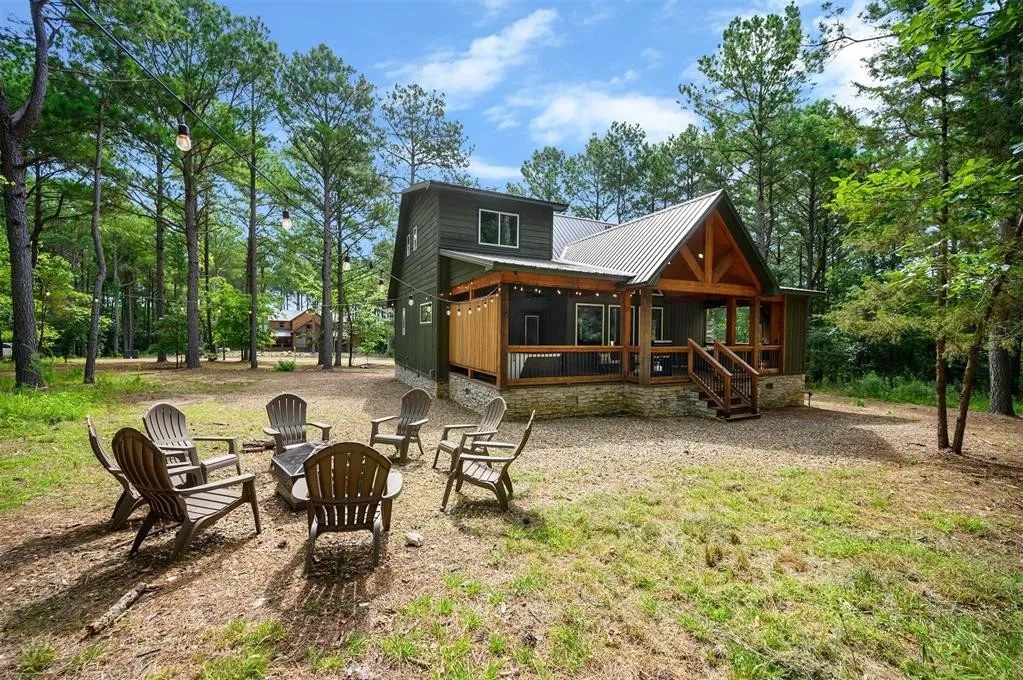 Gilded Spur backyard in Broken Bow OK before the Yellowwood Atelier rebuild: bare yard, plain adirondacks around a fire ring, no pool, no wellness installations, no landscaping