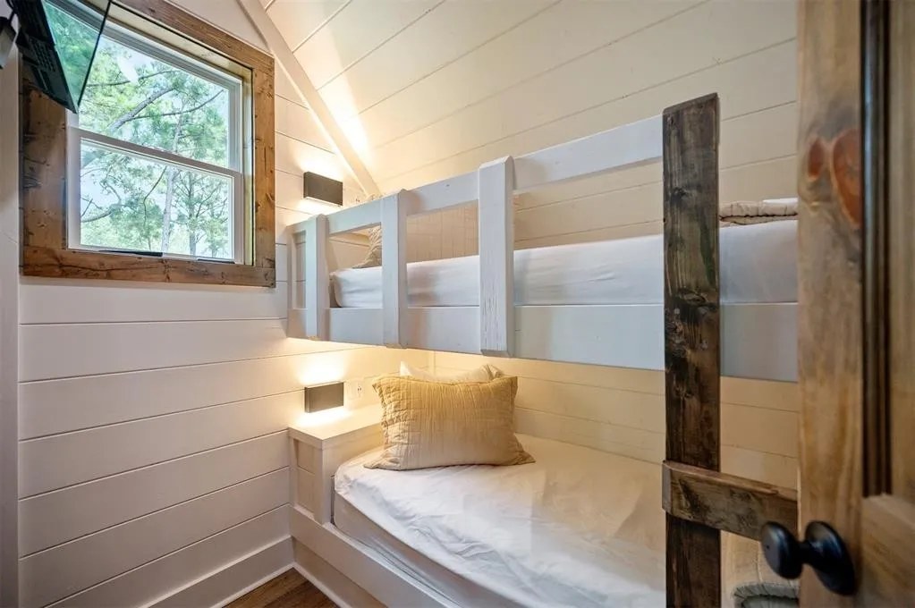 Gilded Spur kids bunk room before Yellowwood Atelier design, Broken Bow OK cabin: plain white-painted built-in bunks, white shiplap walls, basic bedding, no styling