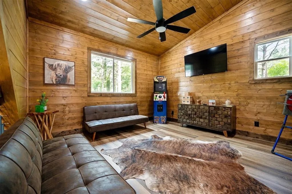 Gilded Spur upstairs loft before Yellowwood Atelier design, Broken Bow OK cabin: empty wood-walled room with basic seating, no game-room programming yet
