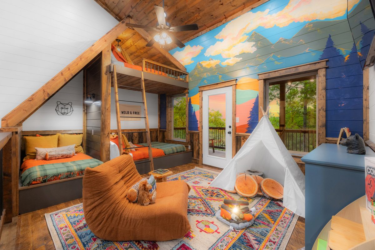 Kids&rsquo; adventure bunk room with a mountain mural and teepee at Lazy Lariat in Broken Bow, Oklahoma