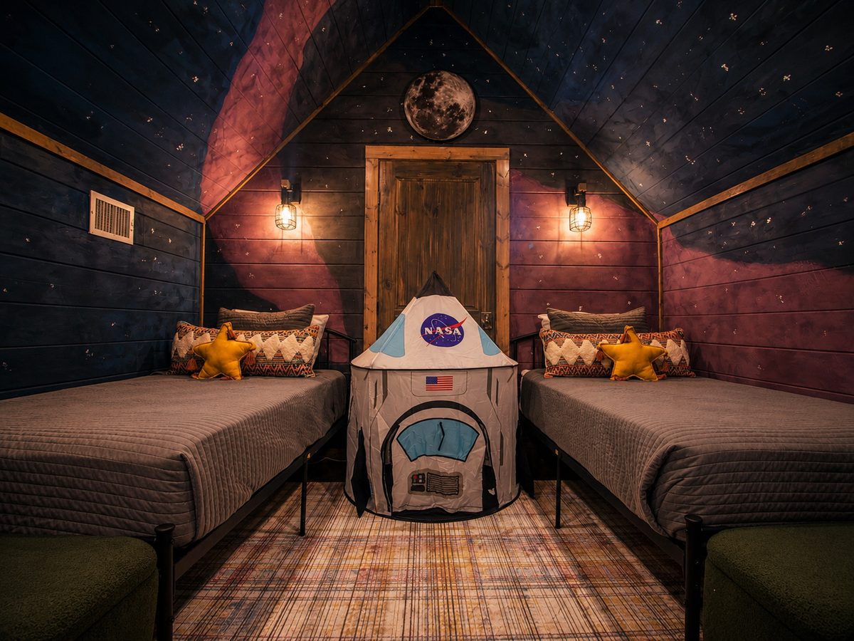 Space-themed kids&rsquo; bunk room with a NASA play tent and painted night sky at Space Cowboy in Hochatown, Oklahoma