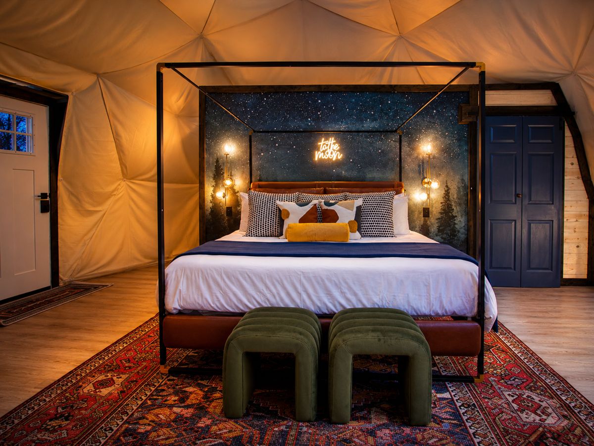 Dome bedroom with a star-mural canopy bed at a geodesic glamping rental