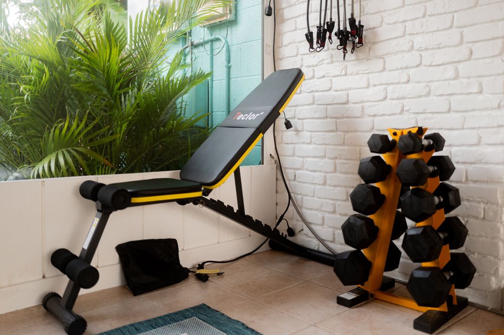In-home gym with dumbbells and bench in a short-term rental