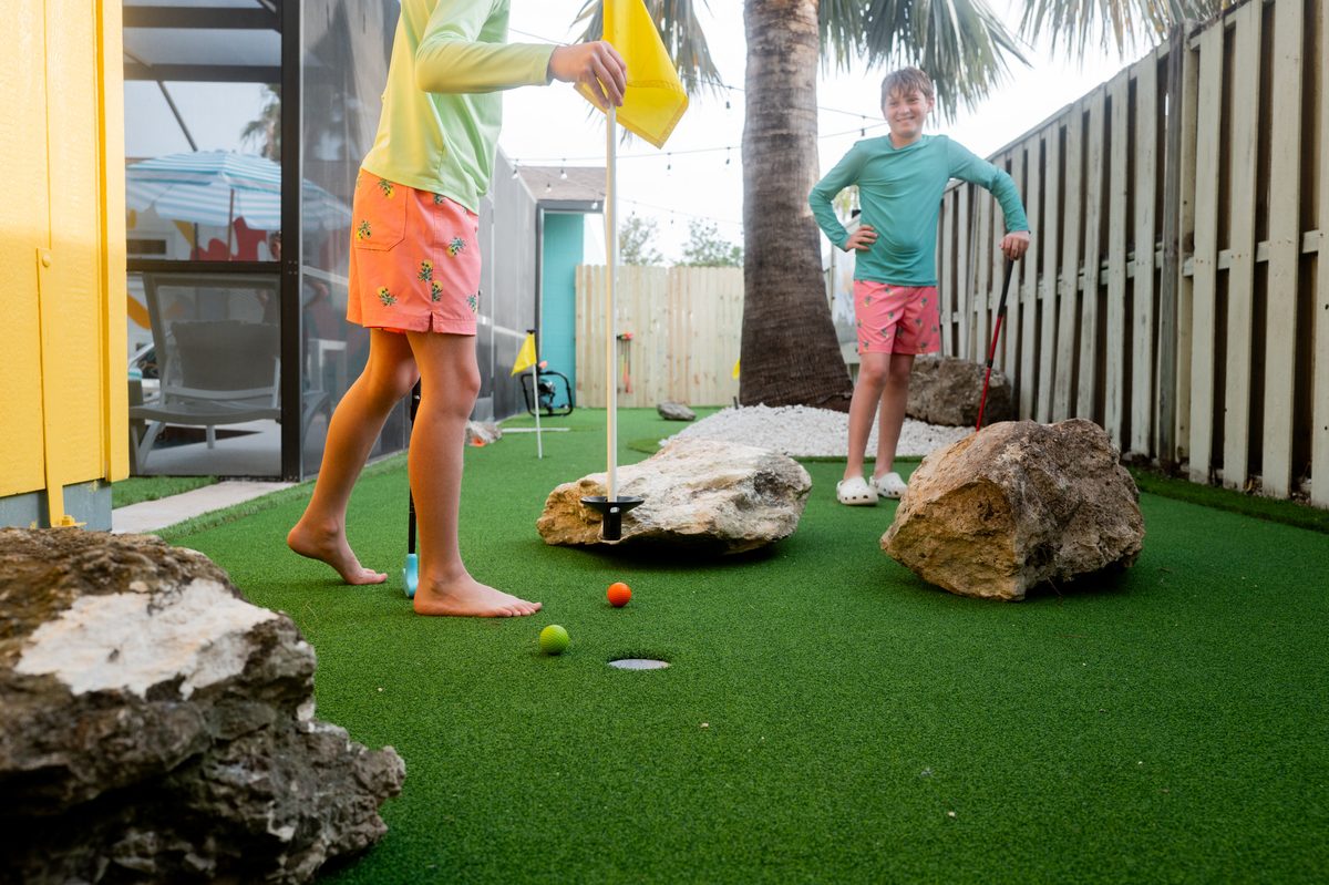 Backyard mini-golf green with palm trees at The Wild Pelican in Bradenton, Florida